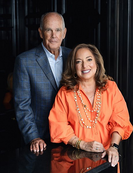 Portrait of a man in a blue and gray suit, and a woman in an orange dress. 