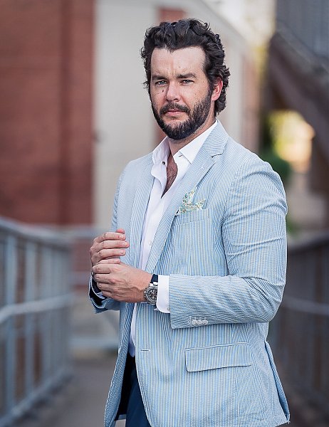 Portrait of a professional St. Louis sales training coach with a beard and a striped blue suit coat. 