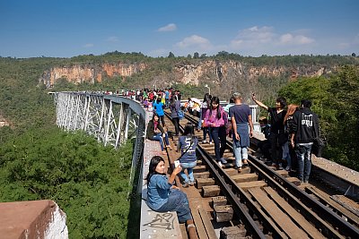 Photographs of tourists walking out onto Gotek Bridge in Shan State, Myanmar. 