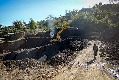 Photograph of heavy machinery excavating a road after a mudslide in Chin State, Myanmar. 