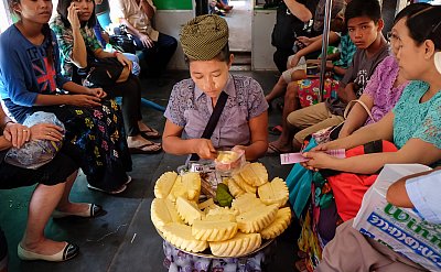 Photograph of a pineapple seller preparing an order on the circular train in Yangon, Myanmar. 